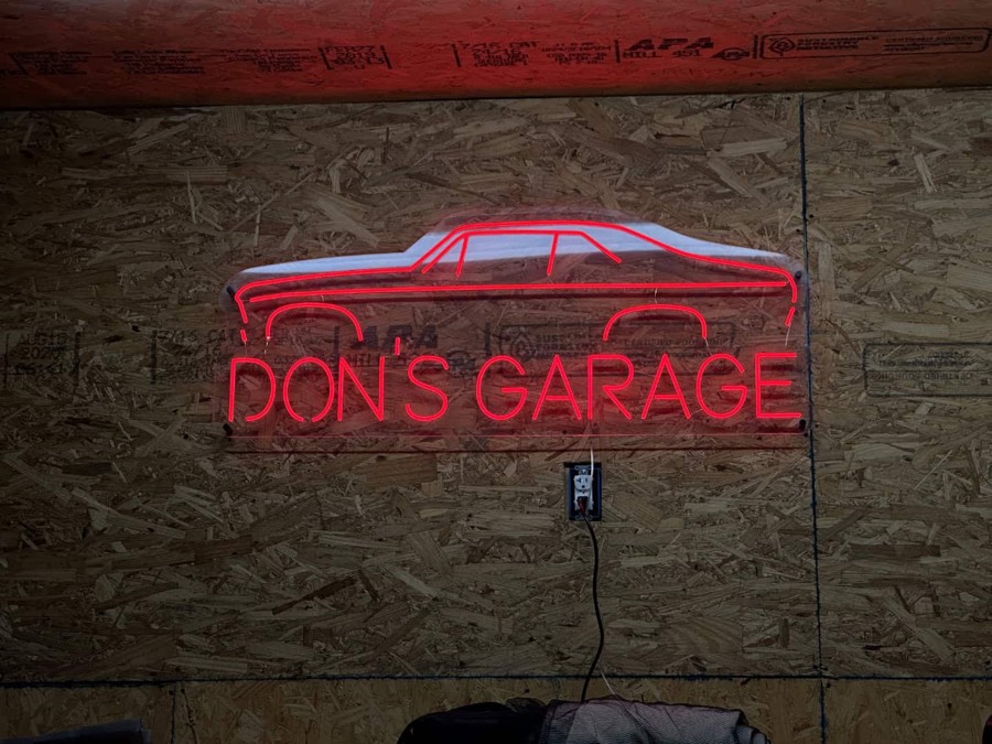 Red neon sign reading Don's Garage with a car outline